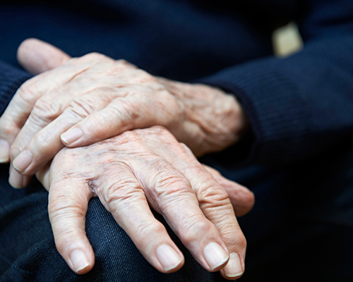 Elderly persons hands resting on lap